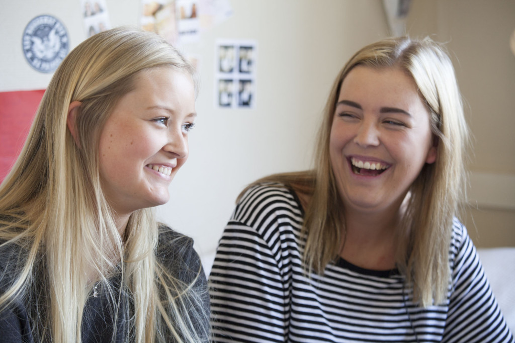 to smilende jenter på internatrom