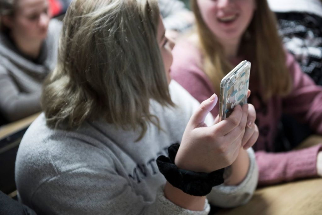 Jente med smarttelefon i hendene.