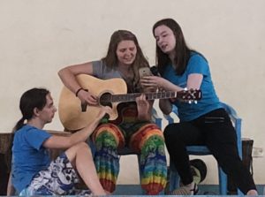 Med en stol og sitte på så klarte Ylva også å opptre på scenen på jenteskolen i Kampala. Her med medelevene Matilde Vadseth Furholm og Sasha Unruh