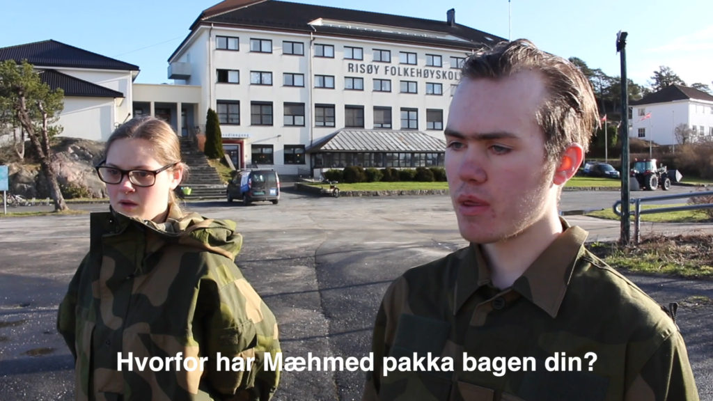 To elever i militærklær foran en stor hvit bygning