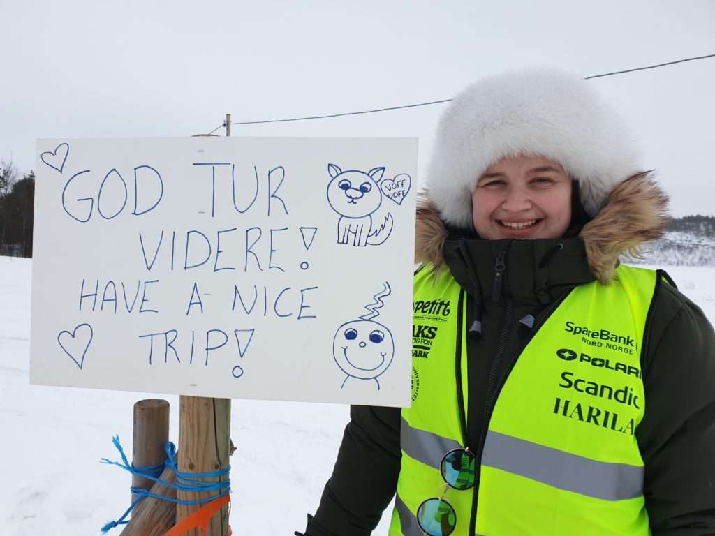 Elev smiler, viser frem plakat med ønske om god tur.
