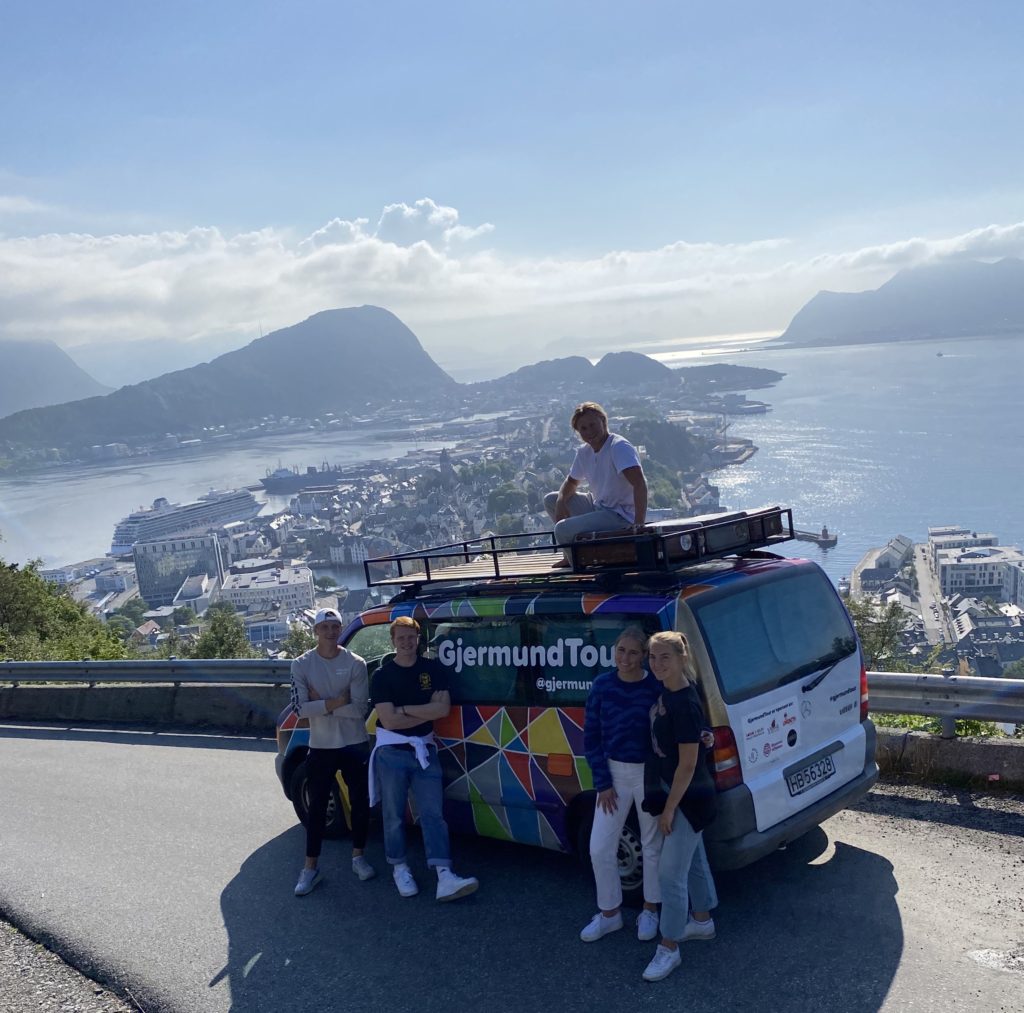 Gjermund oppå bilen, fire medelever rundt