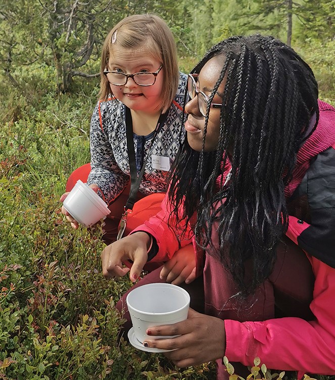 To elever plukker bær i skogen.